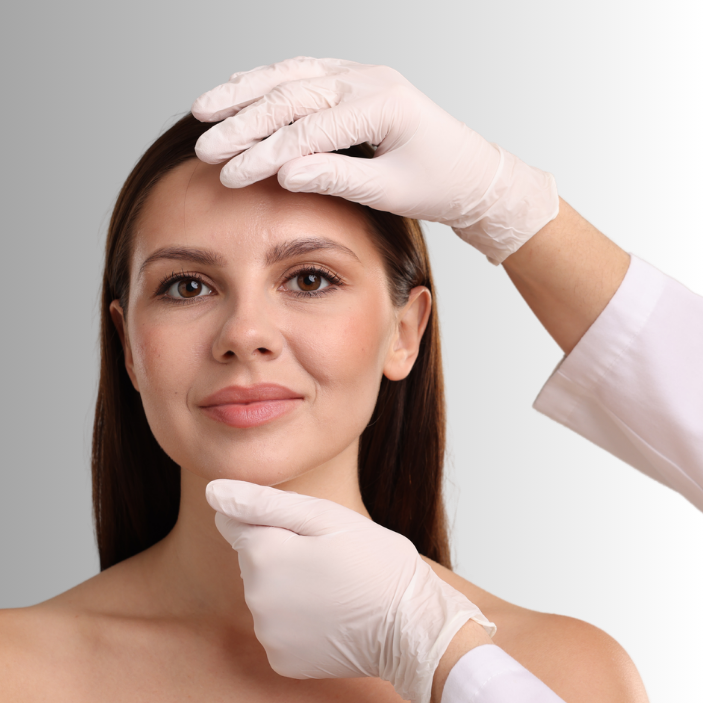 Woman with hands in white gloves examining her face against a gray background
