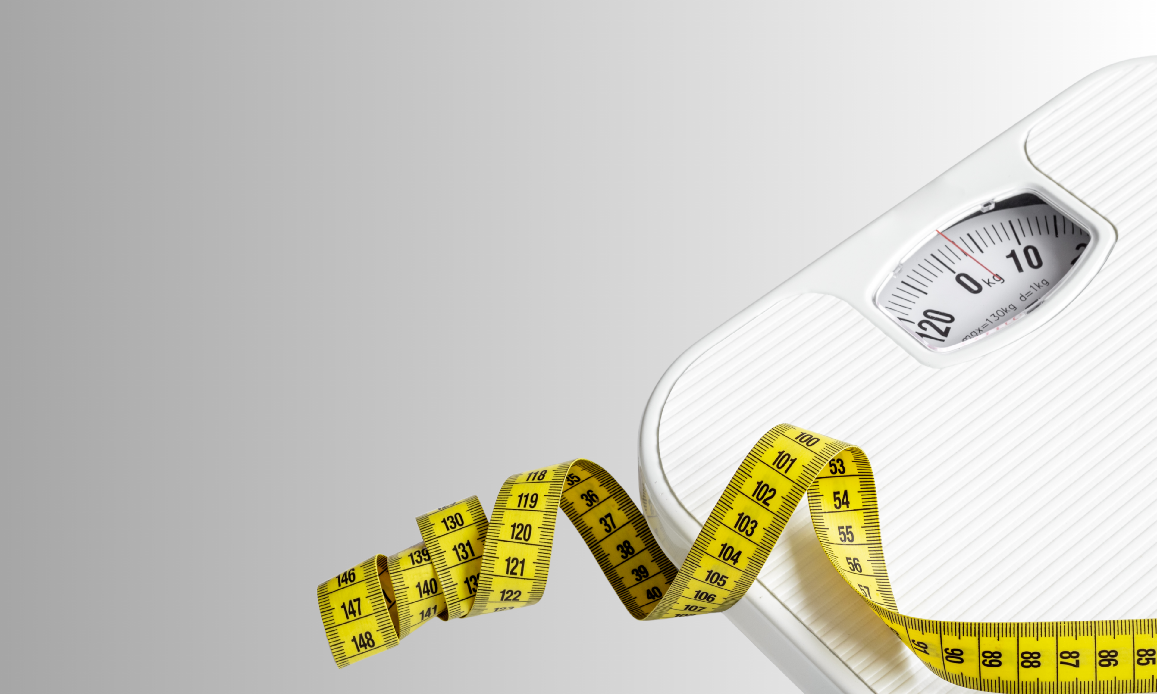 White bathroom scale with a yellow measuring tape on a light gray background
