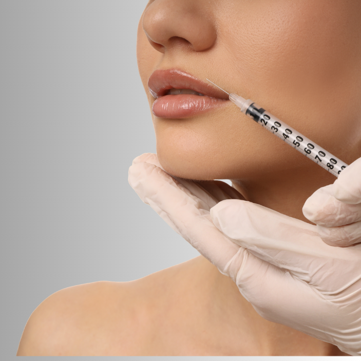 Person receiving a facial injection with a syringe on a gray background